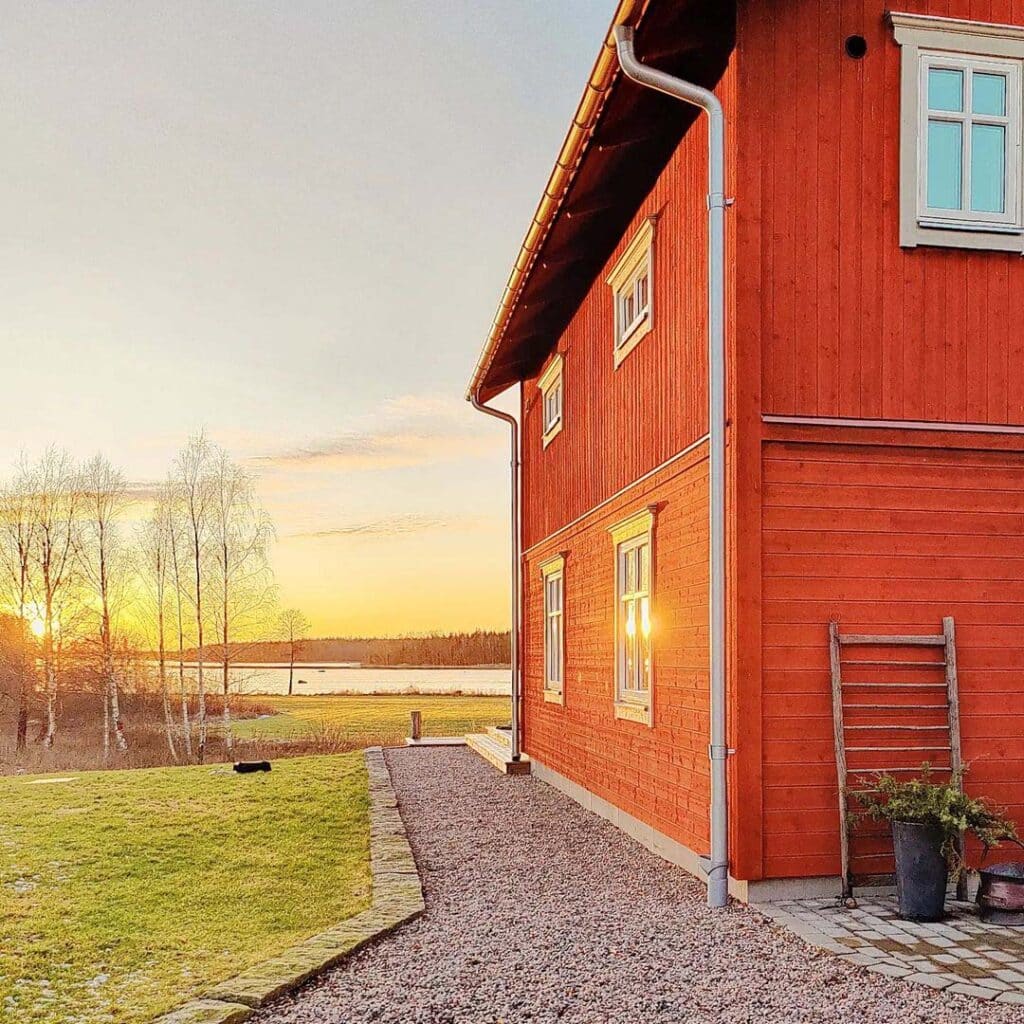 Vackert rött hus i solnedgången.