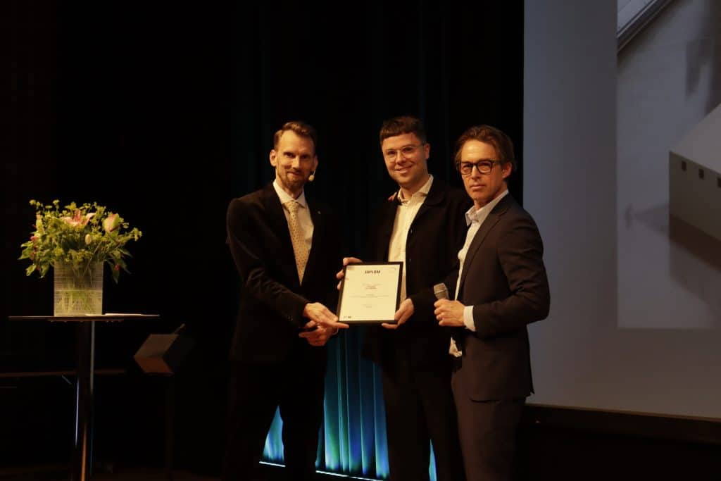 Stellan Gulde tar emot Falu Rödfärg-stipendiet från Martin Jansson, vd på Falu Rödfärg.